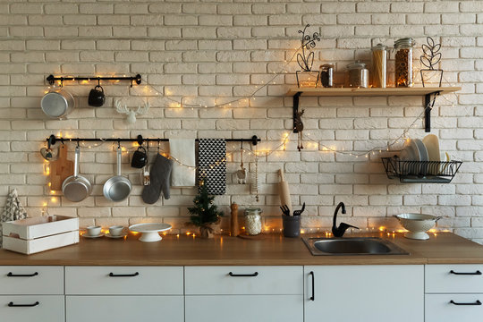 New Year and Christmas 2018. Festive kitchen in Christmas decorations. Candles, spruce branches, wooden stands, table laying.
