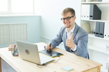 Designer, artist and web design concept - Portrait of young man using digital pen tablet and laptop in the office