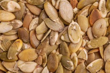 Heap of fresh pumpkin seeds background. Close up