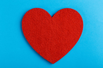 Red felt heart on bright blue background. St. Valentine's day