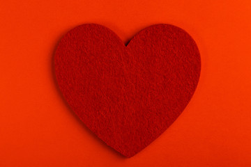 Red felt heart on bright red background. St. Valentine's day