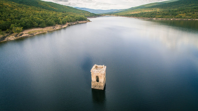 Torre de la iglesia del pueblo "La Muedra" hundida en un pantano. Soria, espa&ntilde;a