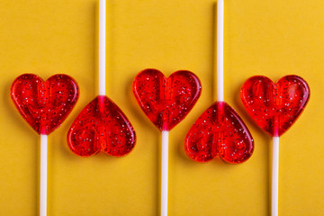 Five red sweet tasty lollipops in shape of heart