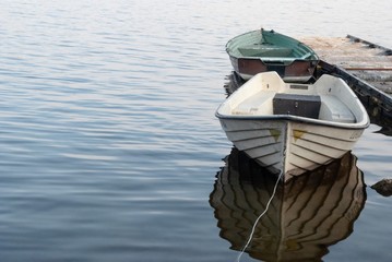 łódki zacumowane przy molo na jeziorze - obrazy, fototapety, plakaty