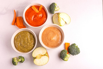 Variation pureed baby food in clay bowls with ingredients