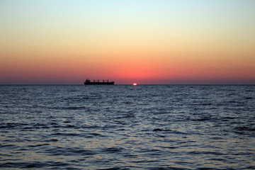 Fototapeta na wymiar Cargo ship at sunset in the Black sea