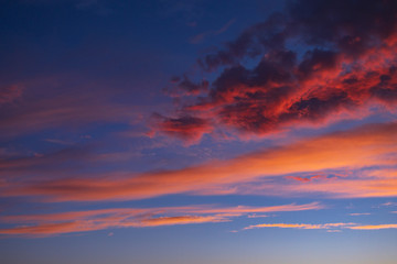 Naklejka na ściany i meble dramatic blue sky with orange clouds at sunset