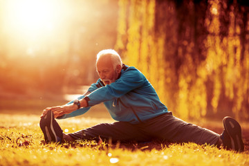 Senior man stretching in the park