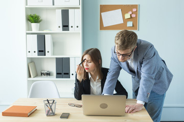 Business, teamwork and people concept - woman and man are working together in office