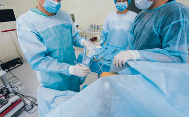 Arthroscope surgery. Orthopedic surgeons in teamwork in the operating room with modern arthroscopic...