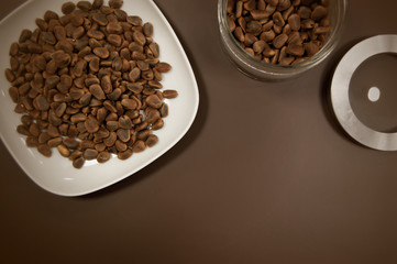 Crude pine nuts in plate and in can on brown background top view. Organic and healthy food.