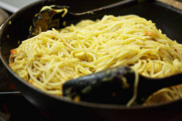 Frying noodles in a wok