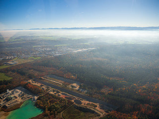 helicopter view from top to munich and bavarian landscape during fog autumn blue sky
