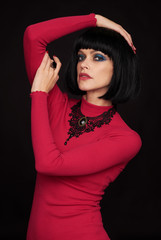 Pretty woman in red dress over black background