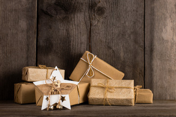 Kraft paper gifts and a Christmas star decoration on an old wooden bookshelf.