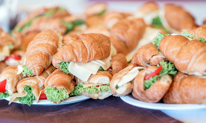 Butter croissants with chicken ham, cheese and parsley on white plate.Croissant sandwich with cheese and vegetables for healthy snack.Appetizer