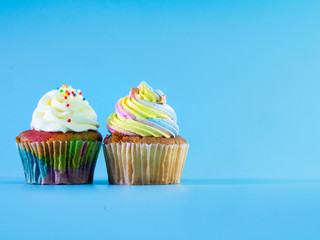Colorful and enteresting cupcake isolated on blue background studio close up shot.