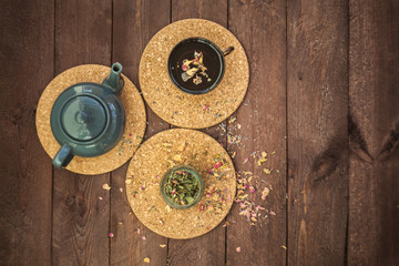 Fototapeta na wymiar a small blue teapot, a mug of tea and dry herbal tea on a wooden background. Herbal medicine. tea from flowers.