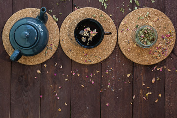 a small blue teapot, a mug of tea and dry herbal tea on a wooden background. Herbal medicine. tea from flowers.