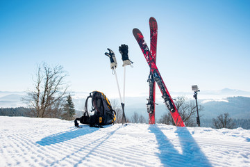 Shot of skiing equipment on top of the ski slope in the mountains winter sports skis backpack...