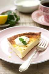 Healthy breakfast made from soft cottage cheese casserole with oatmeal and lemon zest, served with sour cream and mint.