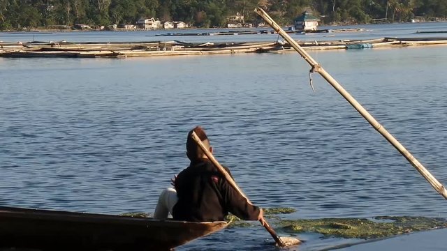 Laguna, Philippines - April 3, 2015: boy earns living as fisherman in a lake using boat