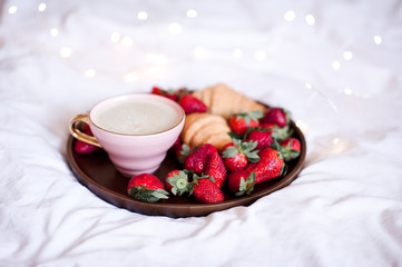 Cup of coffee with fresh strawberry and cake in bed. Good morning. Breakfast.