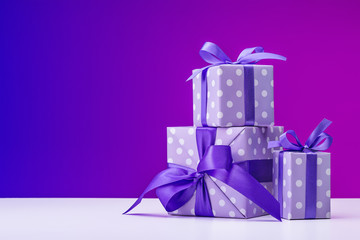 Boxes with gifts in elegant paper on bright table, preparing for holiday.