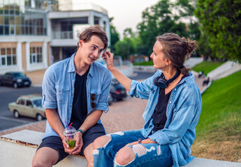 Lovely young hipster couple dating during summer sunset. they wear jeans clothes. modern youth relationship.