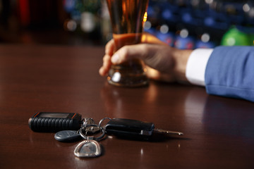 Close up view of drunk man giving car key to woman, on blurred background. Don't drink and drive concept
