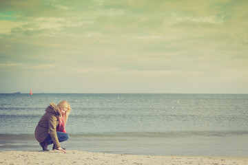 Woman relaxing on beach, cold day