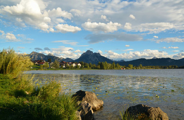 view of the beautiful Hopfensee lake with the Alps in the background in Bavaria, Germany