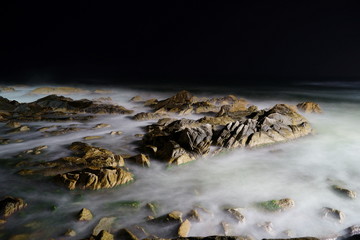 ocean with rocks at night