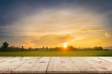 Fototapeta na wymiar Rice field sunset and Empty wood table for product display and montage.