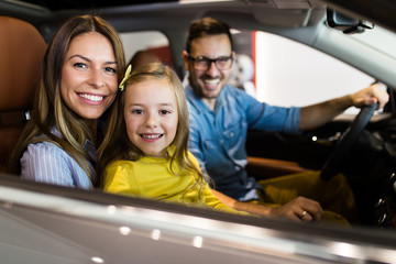 Happy family buying a new car at the car showroom.