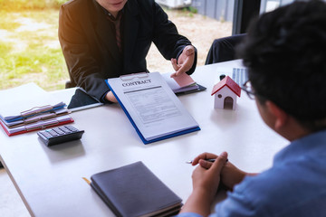 Businessman lawyer explain the documents contact at office desk. home protection, family, insurance.rent house concept .