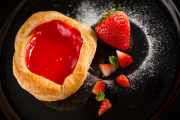 Strawberry jam pie, homemade bakery on black dish, selective focus
