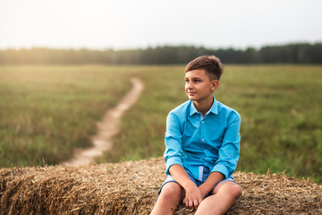 Naklejka na ściany i meble portrait of a cute teen boy in summer in nature