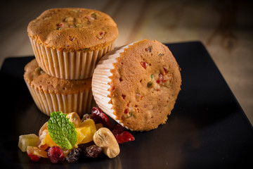 Cashew nut and mixed dry fruits cupcake, homemade muffins with cashew topping on black dish, selective focus, copy space