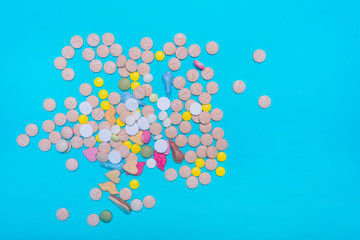 Assorted pharmaceutical medicine pills, tablets and capsules on blue background. Copy space for text. Medicine. top view