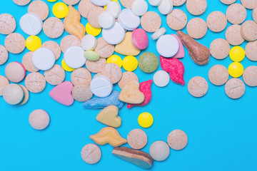 Assorted pharmaceutical medicine pills, tablets and capsules on blue background. Copy space for text. Medicine. top view