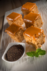 Milk tea cake with dried tea leaves, homemade bakery on white dish, selective focus