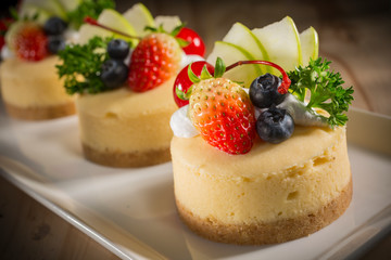 Cheesecake With Fruit Topping, Mixed fruit Cheesecake, Homemade cake on white dish, selective focus