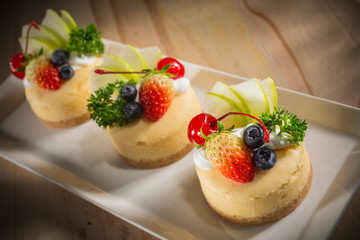 Cheesecake With Fruit Topping, Mixed fruit Cheesecake, Homemade cake on white dish, selective focus