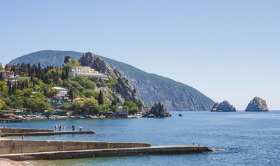 View of the village, located on the rocky shore of the Black sea, and the breakwaters in the foreground.