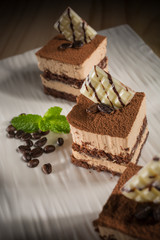 Creamy and layer Coffee cake, Homemade bakery pastry with coffee beans on white dish, selective focus 