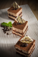 Creamy and layer Coffee cake, Homemade bakery pastry with coffee beans on white dish, selective focus 