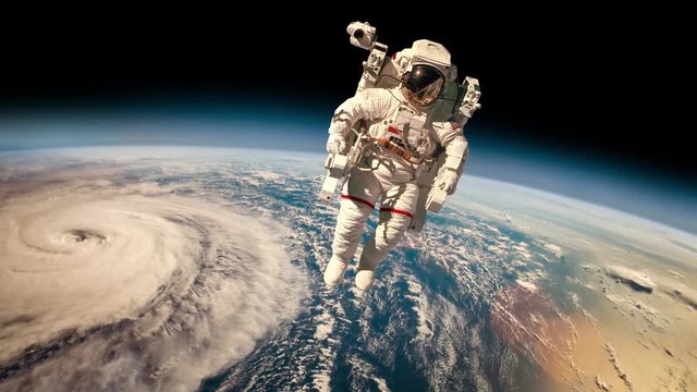 Astronaut in outer space against the backdrop of the planet earth. Typhoon over planet Earth. Elements of this image furnished by NASA.