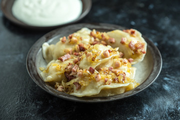 traditional Polish cuisine - delicious, homemade dumplings, topped with fried onion and smoked bacon