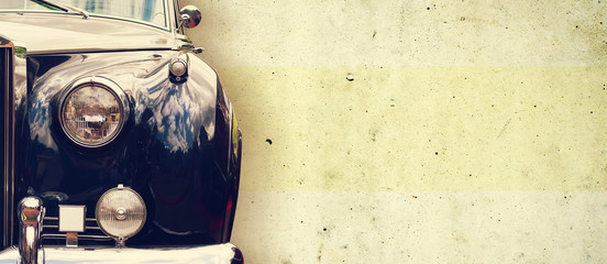 The headlight of the old beautiful car on the background of a concrete wall. Copy space. Concept...
